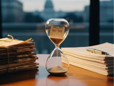 golden hourglass beside old and updated estate planning documents